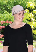 woman outside wearing beige hat for cancer patients