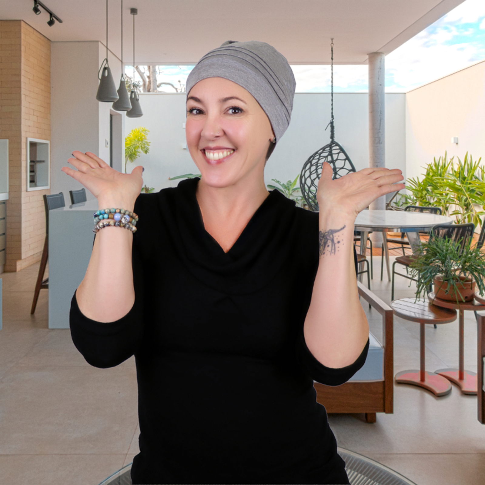 Woman on summer patio wearing heather grey slouchy beanie for chemo headwear. 
