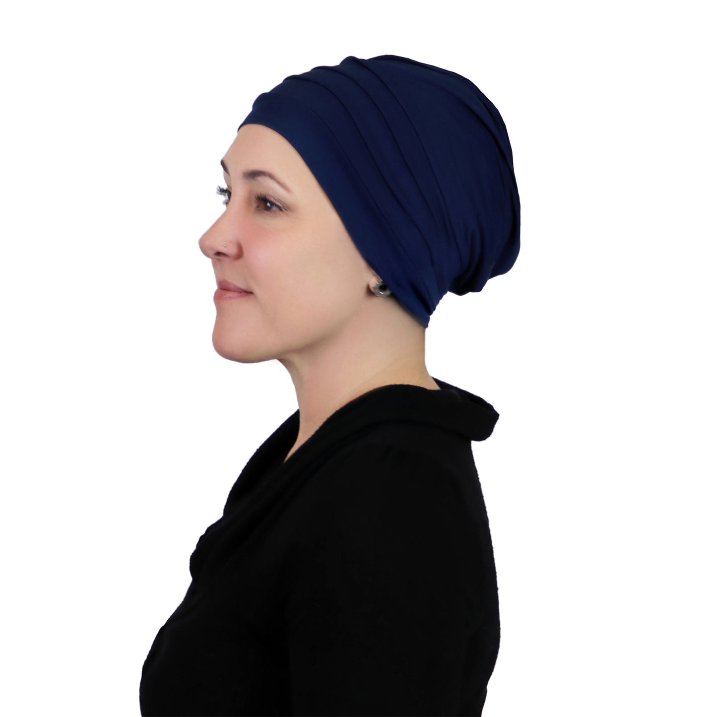 Woman wearing navy blue slouchy beanie for chemo headwear. Side view showing fullness in the back 