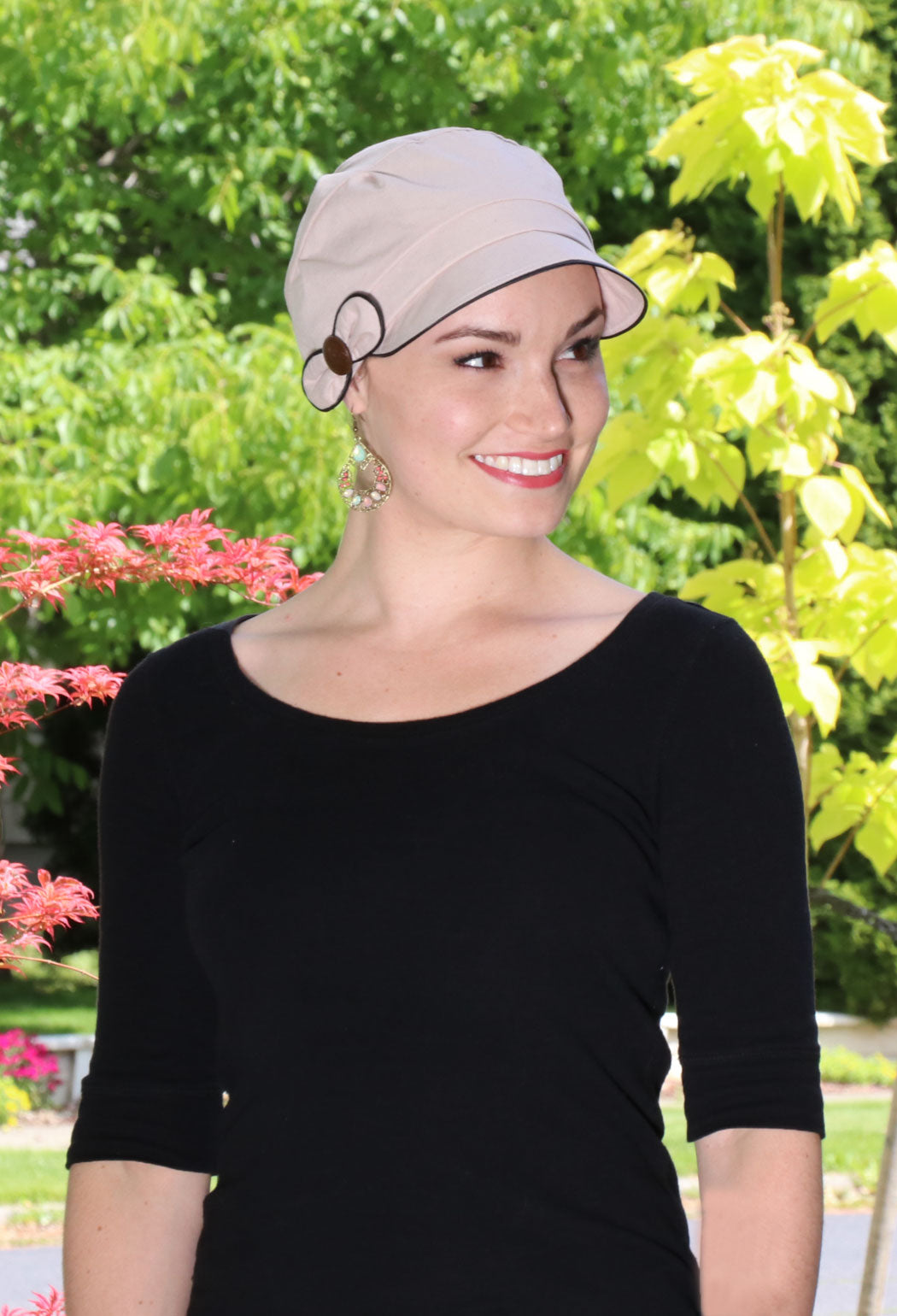 woman outside wearing beige hat for cancer patients